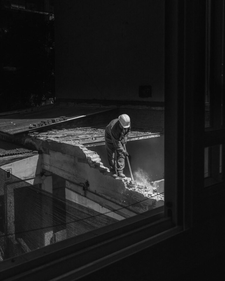 Construction Worker with Hammer on Rooftop